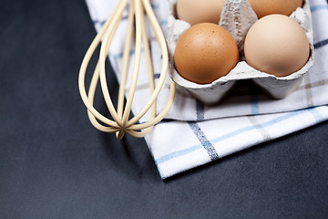 Image showing Eggs in cardboard box, towel and whisker closeup on backboard ba