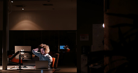 Image showing man working on computer in dark office