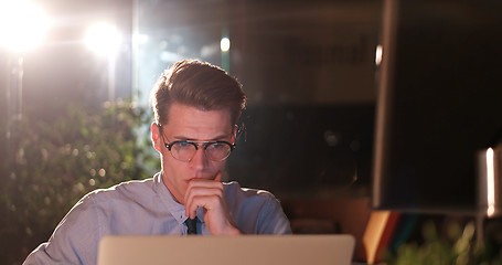 Image showing man working on computer in dark office