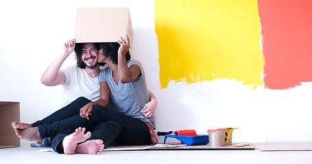 Image showing young multiethnic couple playing with cardboard boxes