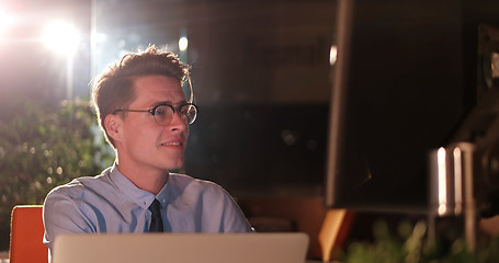 Image showing man working on computer in dark office