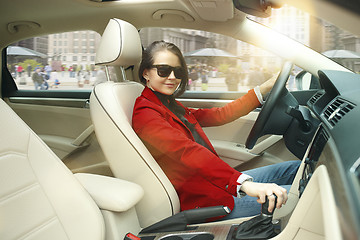 Image showing Driving around city. Young attractive woman driving a car