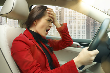 Image showing Driving around city. Young attractive woman driving a car