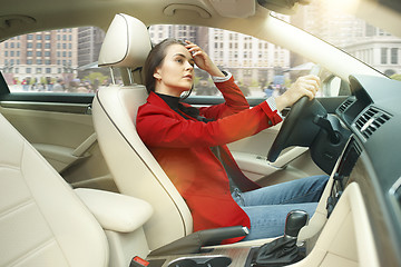 Image showing Driving around city. Young attractive woman driving a car