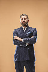 Image showing Male beauty concept. Portrait of a fashionable young man with stylish haircut wearing trendy suit posing over pastel background.