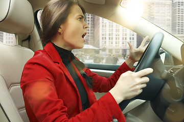 Image showing Driving around city. Young attractive woman driving a car