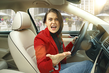 Image showing Driving around city. Young attractive woman driving a car