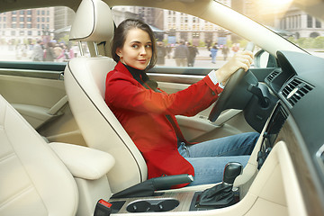 Image showing Driving around city. Young attractive woman driving a car