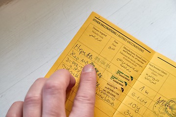 Image showing Vaccination certificate shown at a desk