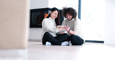 Image showing Young Couple using digital tablet on the floor