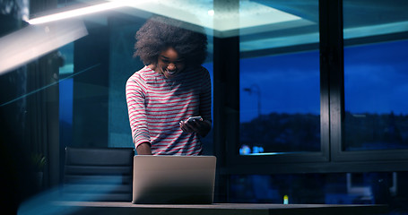 Image showing black businesswoman using a laptop in night startup office