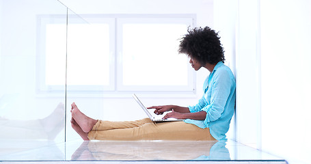 Image showing black women using laptop computer on the floor