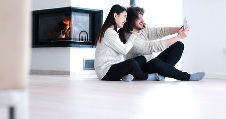 Image showing Young Couple using digital tablet on the floor