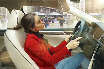 Image showing Driving around city. Young attractive woman driving a car