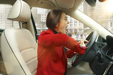 Image showing Driving around city. Young attractive woman driving a car