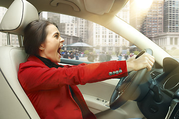 Image showing Driving around city. Young attractive woman driving a car