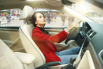 Image showing Driving around city. Young attractive woman driving a car