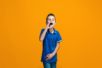 Image showing Isolated on orange young casual teen boy shouting at studio