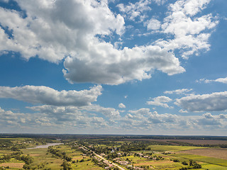 Image showing Amazing landscape with fields, country and river on a background of blue cloudy sky in a summer day. Aerial view from drone.