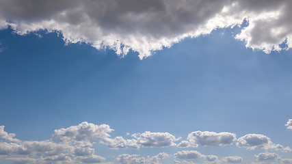 Image showing Natural frame from white clouds on a background of blue sky with sunbeams. Copy space.