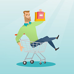 Image showing Young caucasian man riding in shopping trolley.