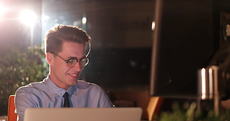 Image showing man working on computer in dark office