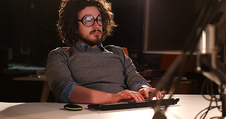 Image showing man working on computer in dark office