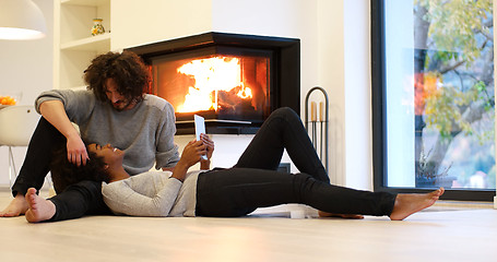 Image showing Young Couple using digital tablet on the floor