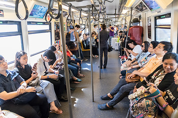 Image showing Passenegers using their mobile phone devices while commuting by city metro in Bangkok, Thailand