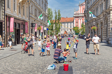 Image showing Urban street artist performing a soap bubble show for children in medieval city center of Slovenian capital Ljubljana