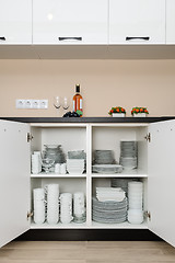 Image showing Dishware storage cabinet with plates and cups inside