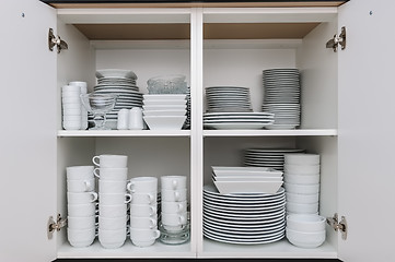 Image showing Dishware storage cabinet with plates and cups inside