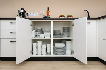 Image showing Dishware storage cabinet with plates and cups inside