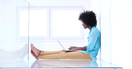 Image showing black women using laptop computer on the floor