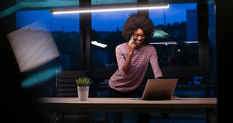 Image showing black businesswoman using a laptop in night startup office