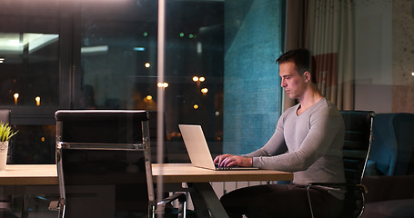Image showing man working on laptop in dark office