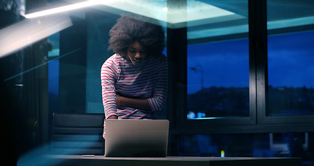 Image showing black businesswoman using a laptop in night startup office