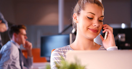 Image showing woman using mobile phone in dark office