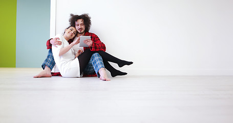 Image showing Young Couple using digital tablet on the floor