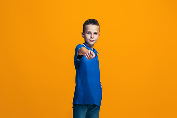Image showing The happy teen boy pointing to you, half length closeup portrait on orange background.