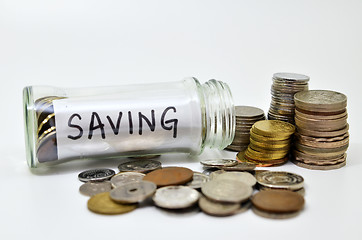 Image showing Saving lable in a glass jar with coins spilling out