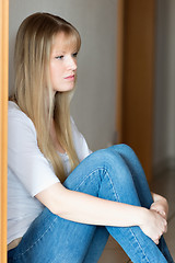 Image showing Sad girl is sitting on the floor