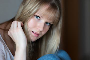 Image showing Sad girl is sitting on the floor