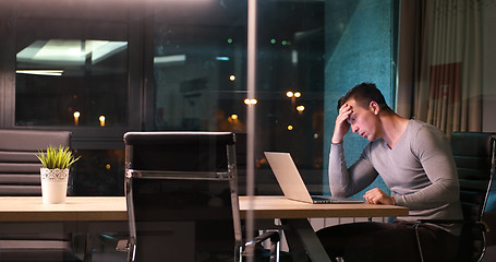 Image showing man working on laptop in dark office