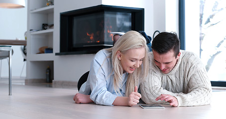 Image showing Young Couple using digital tablet on the floor