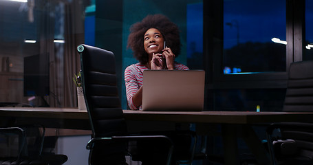 Image showing black businesswoman using a laptop in night startup office