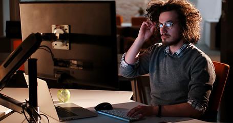 Image showing man working on computer in dark office