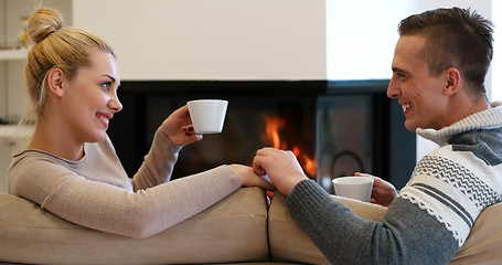 Image showing Young couple  in front of fireplace