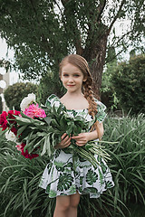 Image showing Portrait of smiling beautiful teenage with bouquet of daisies, against green of summer park.