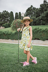 Image showing Little girl just swing golf ball on golf course fairway